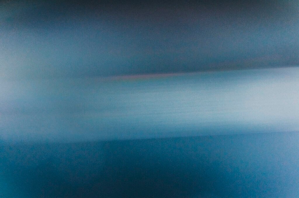 EMDR Therapy 1 Abstract photograph of a horizontal band of bright light cutting across deep navy, echoing the light-through-dark imagery used on the Trauma-Informed Therapy page